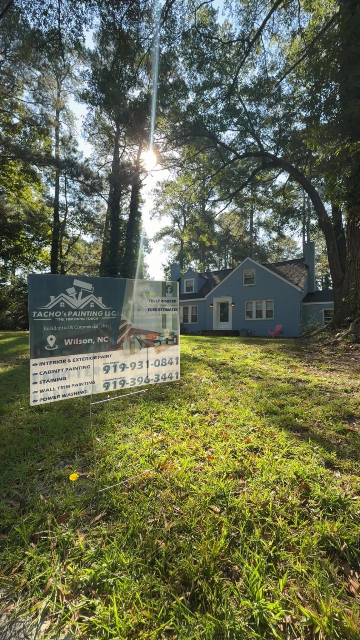 Tacho Painting LLC yard sign in front of completed blue exterior repaint project in Wilson NC