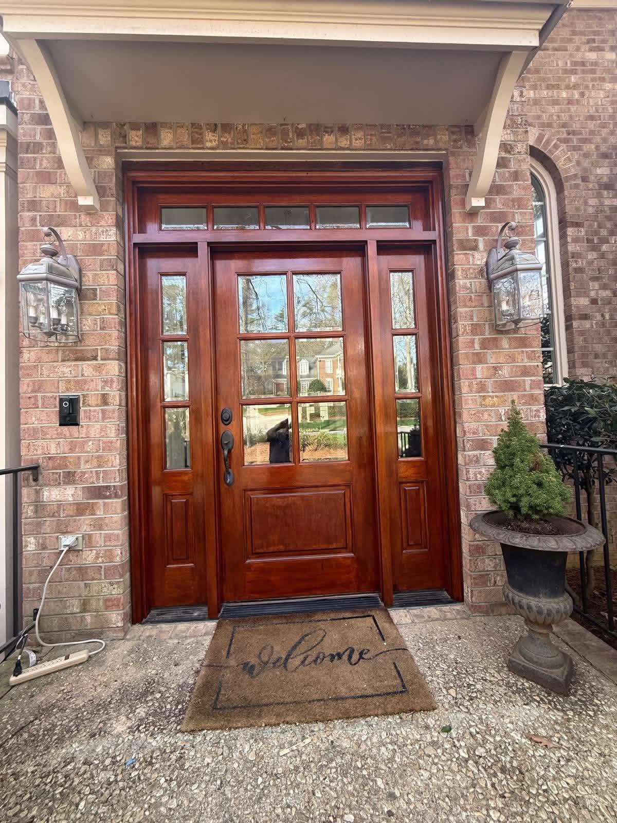 Refinished mahogany front door with sidelights and transom on brick home by Tacho Painting LLC