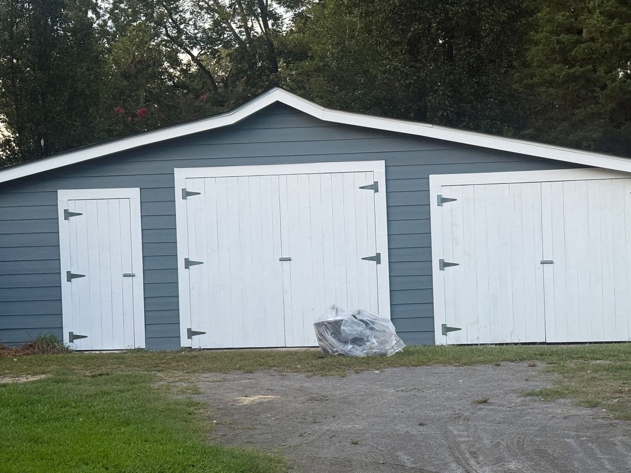 Three-bay outbuilding painted slate gray with white doors by Tacho Painting LLC
